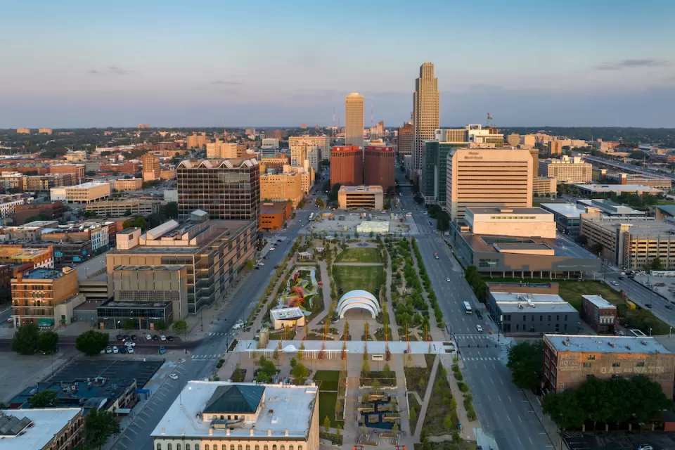 An aerial view of a park and the streets and high-rises of Downtown Omaha.